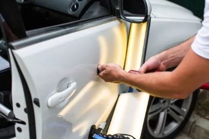 Paintless dent repair on a car door